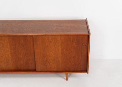 Teak sideboard by Nils Jonsson for Hugo Troeds (Sweden, 1950s). Elegant sideboard by Swedish designer Nils Jonsson, executed in warm teak. The clean, architectural form is complemented by tapered legs and balanced proportions. A distinctive feature of this piece is the set of sculpted, stepped drawers, offering both visual rhythm and practical storage. Sliding doors reveal generous interior space, making the sideboard as functional as it is refined. A timeless example of Scandinavian modern design, presented in excellent vintage condition.