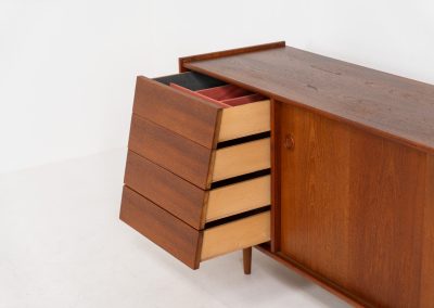 Teak sideboard by Nils Jonsson for Hugo Troeds (Sweden, 1950s). Elegant sideboard by Swedish designer Nils Jonsson, executed in warm teak. The clean, architectural form is complemented by tapered legs and balanced proportions. A distinctive feature of this piece is the set of sculpted, stepped drawers, offering both visual rhythm and practical storage. Sliding doors reveal generous interior space, making the sideboard as functional as it is refined. A timeless example of Scandinavian modern design, presented in excellent vintage condition.