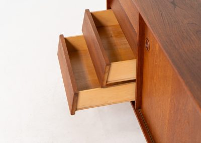 Teak sideboard by Nils Jonsson for Hugo Troeds (Sweden, 1950s). Elegant sideboard by Swedish designer Nils Jonsson, executed in warm teak. The clean, architectural form is complemented by tapered legs and balanced proportions. A distinctive feature of this piece is the set of sculpted, stepped drawers, offering both visual rhythm and practical storage. Sliding doors reveal generous interior space, making the sideboard as functional as it is refined. A timeless example of Scandinavian modern design, presented in excellent vintage condition.