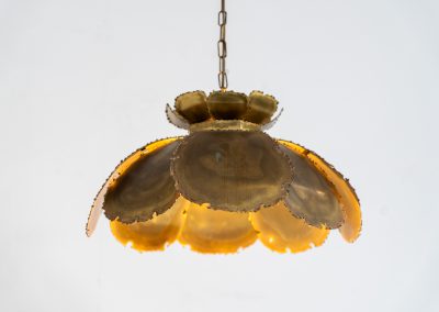 Flower-shaped pendant light by Svend Aage Holm Sørensen (Denmark, 1960s). An exceptional Brutalist pendant, crafted from layered, flame-cut and acid-treated brass slats. The sculptural construction creates a striking interplay of light and shadow, while the beautifully developed patina enhances its raw, organic character. A true eye-catcher with strong presence. In original, well-preserved condition. Marked by the maker.