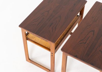 “Model 219” nesting tables by Johannes Andersen & Illum Wickelso for CFC Silkeborg (Denmark, 1960s). These tables are crafted from rosewood and feature a sleek and functional design, allowing them to nest seamlessly within one another. They offer amazing details like the rattan magazine shelf, the mesmerizing woodgrain and the stunning wood connections Versatile and stylish, they serve perfectly as side tables or coffee tables, adapting effortlessly to various interior settings. All three tables are in mint condition. Marked by maker.