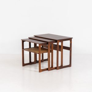 “Model 219” nesting tables by Johannes Andersen & Illum Wickelso for CFC Silkeborg (Denmark, 1960s). These tables are crafted from rosewood and feature a sleek and functional design, allowing them to nest seamlessly within one another. They offer amazing details like the rattan magazine shelf, the mesmerizing woodgrain and the stunning wood connections Versatile and stylish, they serve perfectly as side tables or coffee tables, adapting effortlessly to various interior settings. All three tables are in mint condition. Marked by maker.