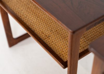 “Model 219” nesting tables by Johannes Andersen & Illum Wickelso for CFC Silkeborg (Denmark, 1960s). These tables are crafted from rosewood and feature a sleek and functional design, allowing them to nest seamlessly within one another. They offer amazing details like the rattan magazine shelf, the mesmerizing woodgrain and the stunning wood connections Versatile and stylish, they serve perfectly as side tables or coffee tables, adapting effortlessly to various interior settings. All three tables are in mint condition. Marked by maker.