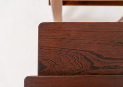 “Model 219” nesting tables by Johannes Andersen & Illum Wickelso for CFC Silkeborg (Denmark, 1960s). These tables are crafted from rosewood and feature a sleek and functional design, allowing them to nest seamlessly within one another. They offer amazing details like the rattan magazine shelf, the mesmerizing woodgrain and the stunning wood connections Versatile and stylish, they serve perfectly as side tables or coffee tables, adapting effortlessly to various interior settings. All three tables are in mint condition. Marked by maker.