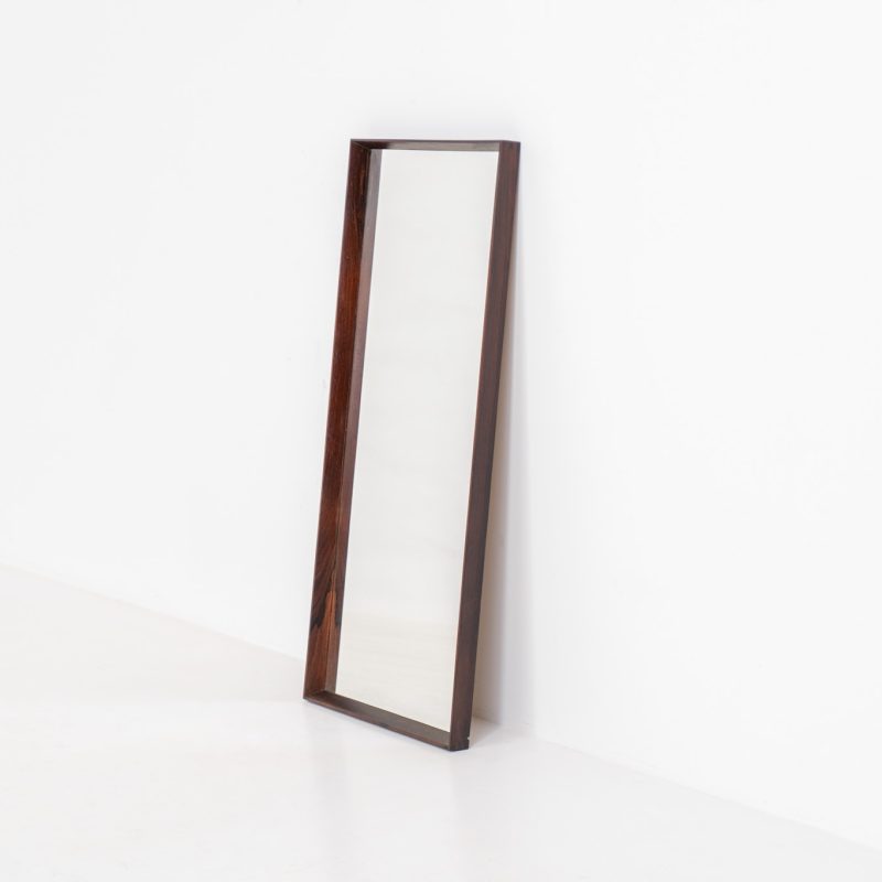 Mid-Century wall mirror in rosewood (Denmark, 1960s). A simple but beautiful wall mirror with a chamfered edge, made out of a dark solid rosewood. In good condition with a minor chip in the wood on the backside.
