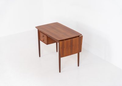 Stunning free standing drop-leaf desk in teak (Denmark, 1960s). It features a cabinet with two drawers and a convenient drop-leaf to add extra space. This writing desk presents itself in good condition!