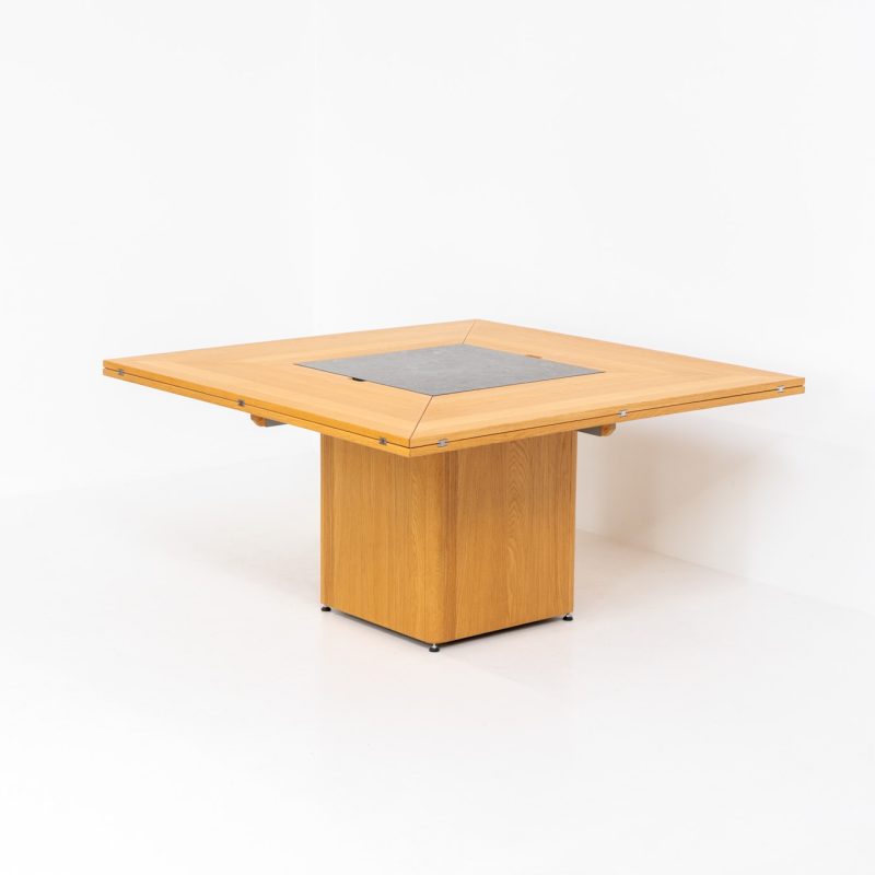 “Cirkante” dining table by Bob & Dries Vanden Berghe for Vanden Berghe Pauvers (Belgium, 1980s). This Belgian icon by Bob Van den Berghe is a masterclass in geometric functionalism. With its signature folding leaves, the Cirkante transforms from a solid square into a spacious octagon, expanding capacity from 8 to 12 people in seconds. By erasing the "head of the table" to put every guest at the center of the conversation. By removing the "head" of the table, its architectural form ensures every guest is at the heart of the conversation. Crafted from premium materials, it remains a timeless sculptural centerpiece for the modern collector. The table remains in amazing condition with minimal wear.