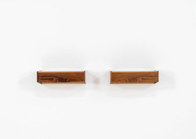 Pair of floating bedside tables in rosewood (Denmark, 1960s). This beautiful pair of bedside tables is easily mounted to the wall and contains a small drawer. They offer a minimalist appearance and a beautiful woodgrain. In very good condition with minimal traces of use visible.