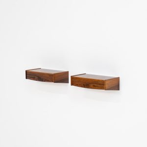 Pair of floating bedside tables in rosewood (Denmark, 1960s). This beautiful pair of bedside tables is easily mounted to the wall and contains a small drawer. They offer a minimalist appearance and a beautiful woodgrain. In very good condition with minimal traces of use visible.