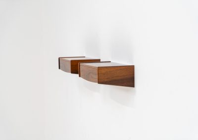 Pair of floating bedside tables in rosewood (Denmark, 1960s). This beautiful pair of bedside tables is easily mounted to the wall and contains a small drawer. They offer a minimalist appearance and a beautiful woodgrain. In very good condition with minimal traces of use visible.