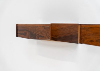Pair of floating bedside tables in rosewood (Denmark, 1960s). This beautiful pair of bedside tables is easily mounted to the wall and contains a small drawer. They offer a minimalist appearance and a beautiful woodgrain. In very good condition with minimal traces of use visible.