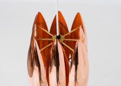 A rare copper version of the “Kastor” pendel by Jo Hammerborg for Fog & Mørup (Denmark, 1960s). An iconic example of Scandinavian modernism! This exceptional high-end piece is constructed from layered copper shells, elegantly separated by brass spacers, offering a spectacular sculptural presence. The interior is lacquered in orange, creating a warm and atmospheric glow. When illuminated, the lamp disperses light beautifully and projects a subtle star-like pattern onto the ceiling. One of Hammerborg's most striking and refined designs remaining in excellent condition, with only a light natural patina to the copper.