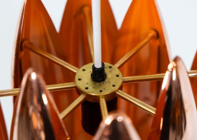 A rare copper version of the “Kastor” pendel by Jo Hammerborg for Fog & Mørup (Denmark, 1960s). An iconic example of Scandinavian modernism! This exceptional high-end piece is constructed from layered copper shells, elegantly separated by brass spacers, offering a spectacular sculptural presence. The interior is lacquered in orange, creating a warm and atmospheric glow. When illuminated, the lamp disperses light beautifully and projects a subtle star-like pattern onto the ceiling. One of Hammerborg's most striking and refined designs remaining in excellent condition, with only a light natural patina to the copper.