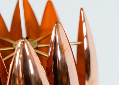 A rare copper version of the “Kastor” pendel by Jo Hammerborg for Fog & Mørup (Denmark, 1960s). An iconic example of Scandinavian modernism! This exceptional high-end piece is constructed from layered copper shells, elegantly separated by brass spacers, offering a spectacular sculptural presence. The interior is lacquered in orange, creating a warm and atmospheric glow. When illuminated, the lamp disperses light beautifully and projects a subtle star-like pattern onto the ceiling. One of Hammerborg's most striking and refined designs remaining in excellent condition, with only a light natural patina to the copper.