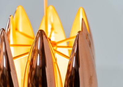 A rare copper version of the “Kastor” pendel by Jo Hammerborg for Fog & Mørup (Denmark, 1960s). An iconic example of Scandinavian modernism! This exceptional high-end piece is constructed from layered copper shells, elegantly separated by brass spacers, offering a spectacular sculptural presence. The interior is lacquered in orange, creating a warm and atmospheric glow. When illuminated, the lamp disperses light beautifully and projects a subtle star-like pattern onto the ceiling. One of Hammerborg's most striking and refined designs remaining in excellent condition, with only a light natural patina to the copper.
