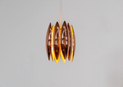 A rare copper version of the “Kastor” pendel by Jo Hammerborg for Fog & Mørup (Denmark, 1960s). An iconic example of Scandinavian modernism! This exceptional high-end piece is constructed from layered copper shells, elegantly separated by brass spacers, offering a spectacular sculptural presence. The interior is lacquered in orange, creating a warm and atmospheric glow. When illuminated, the lamp disperses light beautifully and projects a subtle star-like pattern onto the ceiling. One of Hammerborg's most striking and refined designs remaining in excellent condition, with only a light natural patina to the copper.