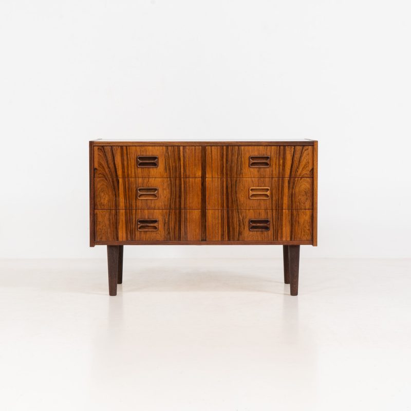 Rosewood chest of drawers by Niels J. Thorsø (Denmark, 1960s). An elegant chest of drawers crafted out of Brazilian rosewood and featuring nice sculptural handles and tapered legs. It is in very good condition.