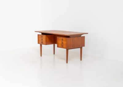Large writing desk in the manner of Kai Kristiansen (Denmark, 1960s). A beautifully crafted freestanding writing desk, executed in the manner of Kai Kristiansen and dating to the 1960s. The design reflects the clean lines, refined proportions, and functional elegance characteristic of Danish modernism. The generously sized top offers ample workspace, making it ideal for both home and professional settings. The front features six spacious drawers, 2 with functional locks, providing practical and secure storage. The fully finished back includes additional storage compartments, allowing the desk to be positioned freely in the center of a room. The desk remains in very good condition, showing only minor age-related wear and light surface scratches consistent with its vintage character.