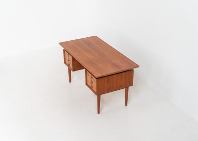 Large writing desk in the manner of Kai Kristiansen (Denmark, 1960s). A beautifully crafted freestanding writing desk, executed in the manner of Kai Kristiansen and dating to the 1960s. The design reflects the clean lines, refined proportions, and functional elegance characteristic of Danish modernism. The generously sized top offers ample workspace, making it ideal for both home and professional settings. The front features six spacious drawers, 2 with functional locks, providing practical and secure storage. The fully finished back includes additional storage compartments, allowing the desk to be positioned freely in the center of a room. The desk remains in very good condition, showing only minor age-related wear and light surface scratches consistent with its vintage character.