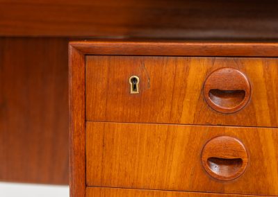Large writing desk in the manner of Kai Kristiansen (Denmark, 1960s). A beautifully crafted freestanding writing desk, executed in the manner of Kai Kristiansen and dating to the 1960s. The design reflects the clean lines, refined proportions, and functional elegance characteristic of Danish modernism. The generously sized top offers ample workspace, making it ideal for both home and professional settings. The front features six spacious drawers, 2 with functional locks, providing practical and secure storage. The fully finished back includes additional storage compartments, allowing the desk to be positioned freely in the center of a room. The desk remains in very good condition, showing only minor age-related wear and light surface scratches consistent with its vintage character.