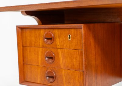 Large writing desk in the manner of Kai Kristiansen (Denmark, 1960s). A beautifully crafted freestanding writing desk, executed in the manner of Kai Kristiansen and dating to the 1960s. The design reflects the clean lines, refined proportions, and functional elegance characteristic of Danish modernism. The generously sized top offers ample workspace, making it ideal for both home and professional settings. The front features six spacious drawers, 2 with functional locks, providing practical and secure storage. The fully finished back includes additional storage compartments, allowing the desk to be positioned freely in the center of a room. The desk remains in very good condition, showing only minor age-related wear and light surface scratches consistent with its vintage character.