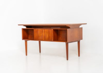 Large writing desk in the manner of Kai Kristiansen (Denmark, 1960s). A beautifully crafted freestanding writing desk, executed in the manner of Kai Kristiansen and dating to the 1960s. The design reflects the clean lines, refined proportions, and functional elegance characteristic of Danish modernism. The generously sized top offers ample workspace, making it ideal for both home and professional settings. The front features six spacious drawers, 2 with functional locks, providing practical and secure storage. The fully finished back includes additional storage compartments, allowing the desk to be positioned freely in the center of a room. The desk remains in very good condition, showing only minor age-related wear and light surface scratches consistent with its vintage character.