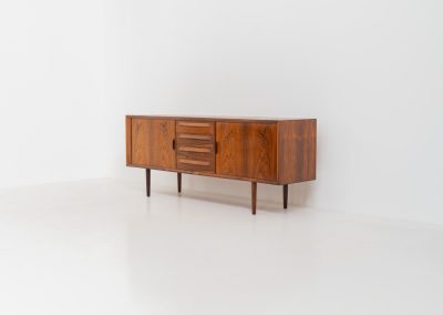 Extremely rare sideboard in rosewood by Svend Aage Larsen for Faarup (Denmark, 1950s). A rare and refined sideboard designed by Svend Aage Larsen and produced by Faarup in the 1950s. The façade is defined by two elegantly crafted tambour sliding doors, complemented by four drawers with beautifully inset handles. The interior layout offers generous and well-organized storage. Executed in richly figured Brazilian rosewood, the cabinet displays a deep and dynamic grain pattern, highlighting the exceptional timber selection and craftsmanship of the period. The piece presents in excellent vintage condition, with only minor age-related wear consistent with its history.