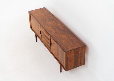 Extremely rare sideboard in rosewood by Svend Aage Larsen for Faarup (Denmark, 1950s). A rare and refined sideboard designed by Svend Aage Larsen and produced by Faarup in the 1950s. The façade is defined by two elegantly crafted tambour sliding doors, complemented by four drawers with beautifully inset handles. The interior layout offers generous and well-organized storage. Executed in richly figured Brazilian rosewood, the cabinet displays a deep and dynamic grain pattern, highlighting the exceptional timber selection and craftsmanship of the period. The piece presents in excellent vintage condition, with only minor age-related wear consistent with its history.