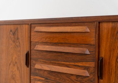 Extremely rare sideboard in rosewood by Svend Aage Larsen for Faarup (Denmark, 1950s). A rare and refined sideboard designed by Svend Aage Larsen and produced by Faarup in the 1950s. The façade is defined by two elegantly crafted tambour sliding doors, complemented by four drawers with beautifully inset handles. The interior layout offers generous and well-organized storage. Executed in richly figured Brazilian rosewood, the cabinet displays a deep and dynamic grain pattern, highlighting the exceptional timber selection and craftsmanship of the period. The piece presents in excellent vintage condition, with only minor age-related wear consistent with its history.