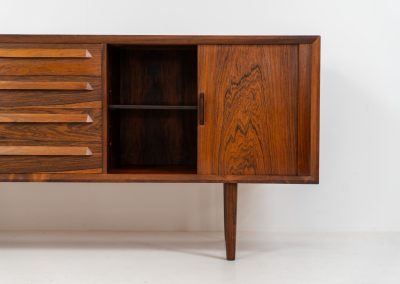 Extremely rare sideboard in rosewood by Svend Aage Larsen for Faarup (Denmark, 1950s). A rare and refined sideboard designed by Svend Aage Larsen and produced by Faarup in the 1950s. The façade is defined by two elegantly crafted tambour sliding doors, complemented by four drawers with beautifully inset handles. The interior layout offers generous and well-organized storage. Executed in richly figured Brazilian rosewood, the cabinet displays a deep and dynamic grain pattern, highlighting the exceptional timber selection and craftsmanship of the period. The piece presents in excellent vintage condition, with only minor age-related wear consistent with its history.