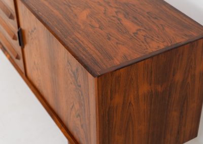 Extremely rare sideboard in rosewood by Svend Aage Larsen for Faarup (Denmark, 1950s). A rare and refined sideboard designed by Svend Aage Larsen and produced by Faarup in the 1950s. The façade is defined by two elegantly crafted tambour sliding doors, complemented by four drawers with beautifully inset handles. The interior layout offers generous and well-organized storage. Executed in richly figured Brazilian rosewood, the cabinet displays a deep and dynamic grain pattern, highlighting the exceptional timber selection and craftsmanship of the period. The piece presents in excellent vintage condition, with only minor age-related wear consistent with its history.