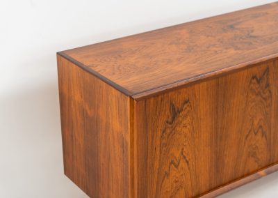 Extremely rare sideboard in rosewood by Svend Aage Larsen for Faarup (Denmark, 1950s). A rare and refined sideboard designed by Svend Aage Larsen and produced by Faarup in the 1950s. The façade is defined by two elegantly crafted tambour sliding doors, complemented by four drawers with beautifully inset handles. The interior layout offers generous and well-organized storage. Executed in richly figured Brazilian rosewood, the cabinet displays a deep and dynamic grain pattern, highlighting the exceptional timber selection and craftsmanship of the period. The piece presents in excellent vintage condition, with only minor age-related wear consistent with its history.