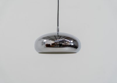 Chrome pendel by Richard Carruters for Ateljé Lyktan (Sweden, 1970s). A sleek and contemporary lamp that perfectly captures the space-age aesthetic of the mid-century era. The high-gloss chrome finish creates a striking mirror effect, reflecting the surrounding interior, while the wide, shallow dome provides a focused yet warm downward glow. The lamp is in amazing condition with some age related wear on the the chrome and the inside lacquer.