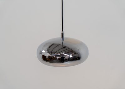 Chrome pendel by Richard Carruters for Ateljé Lyktan (Sweden, 1970s). A sleek and contemporary lamp that perfectly captures the space-age aesthetic of the mid-century era. The high-gloss chrome finish creates a striking mirror effect, reflecting the surrounding interior, while the wide, shallow dome provides a focused yet warm downward glow. The lamp is in amazing condition with some age related wear on the the chrome and the inside lacquer.