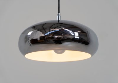 Chrome pendel by Richard Carruters for Ateljé Lyktan (Sweden, 1970s). A sleek and contemporary lamp that perfectly captures the space-age aesthetic of the mid-century era. The high-gloss chrome finish creates a striking mirror effect, reflecting the surrounding interior, while the wide, shallow dome provides a focused yet warm downward glow. The lamp is in amazing condition with some age related wear on the the chrome and the inside lacquer.