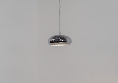 Chrome pendel by Richard Carruters for Ateljé Lyktan (Sweden, 1970s). A sleek and contemporary lamp that perfectly captures the space-age aesthetic of the mid-century era. The high-gloss chrome finish creates a striking mirror effect, reflecting the surrounding interior, while the wide, shallow dome provides a focused yet warm downward glow. The lamp is in amazing condition with some age related wear on the the chrome and the inside lacquer.