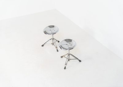 Rare pair of Dulton stools by Yasu Satamoto for Dulton Co. (Japan, 1970s). A striking and unconventional pair of chrome stools designed by experimental Japanese designer Yasu Satamoto for Dulton Co. The concept is both playful and industrial: a sculptural tractor seat mounted onto a drummer’s stool base, executed in stainless steel. The stools are easily foldable and collapsible, making them practical as well as visually distinctive. They remain in good vintage condition, showing a beautiful patina with light, age-related rust marks. We have chosen to preserve this finish to enhance their authentic character, but they can of course be polished and the rust removed upon request.