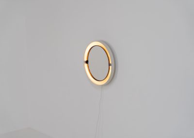 Model A41 backlit wall mirror by Allibert (Germany, 1970s). A striking space age design by Allibert, Germany. This Model A41 mirror is crafted from molded plastic and designed to hold four E14 bulbs inside, operated by a pull switch on the side. When illuminated, the translucent plastic frame softly diffuses the light, creating a warm halo effect around the mirror glass. The mirror can be tilted up or down, adding both functionality and a sculptural presence to the piece. Presented in good vintage condition with light, age-appropriate wear.