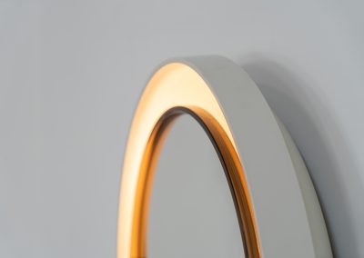 Model A41 backlit wall mirror by Allibert (Germany, 1970s). A striking space age design by Allibert, Germany. This Model A41 mirror is crafted from molded plastic and designed to hold four E14 bulbs inside, operated by a pull switch on the side. When illuminated, the translucent plastic frame softly diffuses the light, creating a warm halo effect around the mirror glass. The mirror can be tilted up or down, adding both functionality and a sculptural presence to the piece. Presented in good vintage condition with light, age-appropriate wear.
