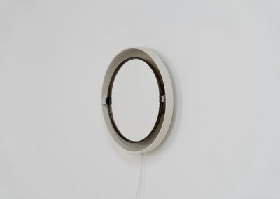Model A41 backlit wall mirror by Allibert (Germany, 1970s). A striking space age design by Allibert, Germany. This Model A41 mirror is crafted from molded plastic and designed to hold four E14 bulbs inside, operated by a pull switch on the side. When illuminated, the translucent plastic frame softly diffuses the light, creating a warm halo effect around the mirror glass. The mirror can be tilted up or down, adding both functionality and a sculptural presence to the piece. Presented in good vintage condition with light, age-appropriate wear.