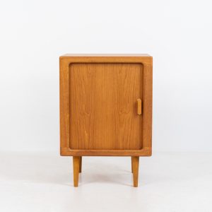 Compact cabinet with tambour door by CFC Silkeborg (Denmark, 1960s). The cabinet is made out of teak and features stunning organic shapes and lots of amazing details, like the tambour door and the rounded handle. The shelve on the inside is adjustable. A perfect piece to use for a record player and vinyls! This piece presents itself in very good condition with no damages, the top has a little discoloration.