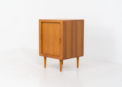 Compact cabinet with tambour door by CFC Silkeborg (Denmark, 1960s). The cabinet is made out of teak and features stunning organic shapes and lots of amazing details, like the tambour door and the rounded handle. The shelve on the inside is adjustable. A perfect piece to use for a record player and vinyls! This piece presents itself in very good condition with no damages, the top has a little discoloration.