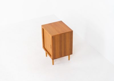 Compact cabinet with tambour door by CFC Silkeborg (Denmark, 1960s). The cabinet is made out of teak and features stunning organic shapes and lots of amazing details, like the tambour door and the rounded handle. The shelve on the inside is adjustable. A perfect piece to use for a record player and vinyls! This piece presents itself in very good condition with no damages, the top has a little discoloration.