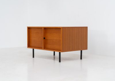 Minimalist cabinet by Gunter Renkel for Rego (Germany, 1960s). Crafted in warm teak, the cabinet features clean architectural lines, two doors, and a beautifully balanced composition. The slender black metal legs create a subtle contrast and give the piece a light, elevated appearance. Compact yet versatile, it works perfectly as a low sideboard, media cabinet, or storage unit in both modern and mid-century interiors. Its in very good vintage condition. Make sure to check out the dimensions as it’s slightly deeper than your average cabinet.