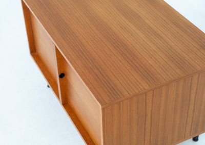 Minimalist cabinet by Gunter Renkel for Rego (Germany, 1960s). Crafted in warm teak, the cabinet features clean architectural lines, two doors, and a beautifully balanced composition. The slender black metal legs create a subtle contrast and give the piece a light, elevated appearance. Compact yet versatile, it works perfectly as a low sideboard, media cabinet, or storage unit in both modern and mid-century interiors. Its in very good vintage condition. Make sure to check out the dimensions as it’s slightly deeper than your average cabinet.