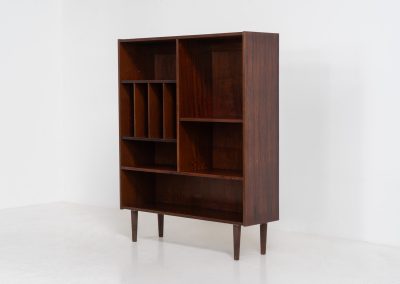 Rosewood bookcase by Aejm Møbler (Denmark, 1960s). Minimalist Danish bookcase crafted in richly grained rosewood. The design is clean and architectural, with well-balanced proportions and a strong vertical rhythm. The cabinet features fixed shelves and four integrated record dividers, making it ideal for vinyl storage while still offering versatile display space. A well-built and functional piece with the original maker's label intact. Presented in good vintage condition with only light, age-appropriate wear.