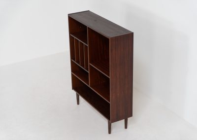 Rosewood bookcase by Aejm Møbler (Denmark, 1960s). Minimalist Danish bookcase crafted in richly grained rosewood. The design is clean and architectural, with well-balanced proportions and a strong vertical rhythm. The cabinet features fixed shelves and four integrated record dividers, making it ideal for vinyl storage while still offering versatile display space. A well-built and functional piece with the original maker's label intact. Presented in good vintage condition with only light, age-appropriate wear.