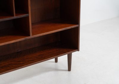 Rosewood bookcase by Aejm Møbler (Denmark, 1960s). Minimalist Danish bookcase crafted in richly grained rosewood. The design is clean and architectural, with well-balanced proportions and a strong vertical rhythm. The cabinet features fixed shelves and four integrated record dividers, making it ideal for vinyl storage while still offering versatile display space. A well-built and functional piece with the original maker's label intact. Presented in good vintage condition with only light, age-appropriate wear.