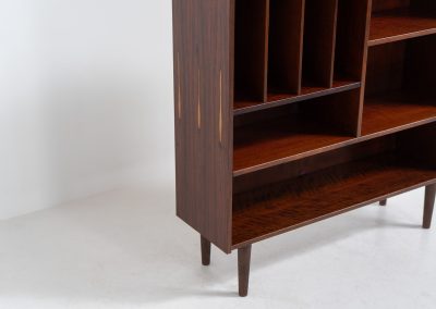 Rosewood bookcase by Aejm Møbler (Denmark, 1960s). Minimalist Danish bookcase crafted in richly grained rosewood. The design is clean and architectural, with well-balanced proportions and a strong vertical rhythm. The cabinet features fixed shelves and four integrated record dividers, making it ideal for vinyl storage while still offering versatile display space. A well-built and functional piece with the original maker's label intact. Presented in good vintage condition with only light, age-appropriate wear.