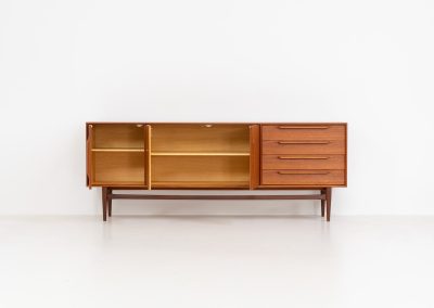 “RT200” sideboard by Heinrich Riestenpatt (Germany, 1960s). A very elegant sideboard by German designer Heinrich Riestenpatt, executed in warm teak. The clean, architectural form is complemented by stunning organic handles and beautifully balanced proportions. A distinctive feature of this piece is the set of sculpted, slightly stepped drawers, offering both visual rhythm and practical storage. Three doors reveal generous interior space, making the sideboard as functional as it is refined. A timeless example of German modern design, presented in excellent vintage condition.